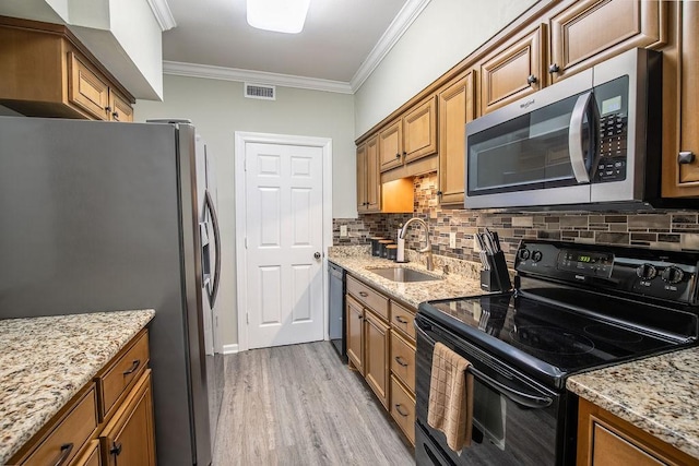 kitchen featuring brown cabinets, visible vents, a sink, and black appliances