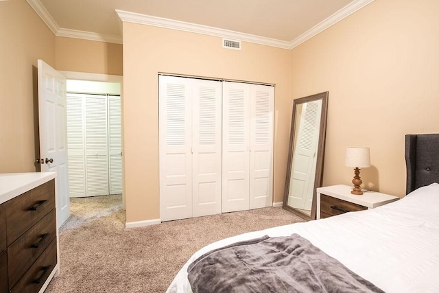 bedroom with ornamental molding, a closet, visible vents, and light colored carpet