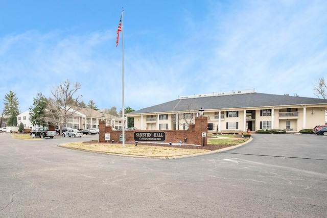 view of building exterior featuring uncovered parking and a residential view