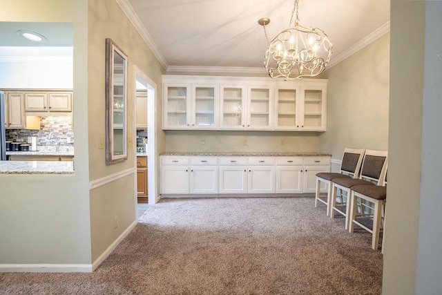 interior space with crown molding, baseboards, a notable chandelier, and light colored carpet