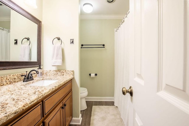 full bathroom featuring toilet, ornamental molding, vanity, wood finished floors, and baseboards