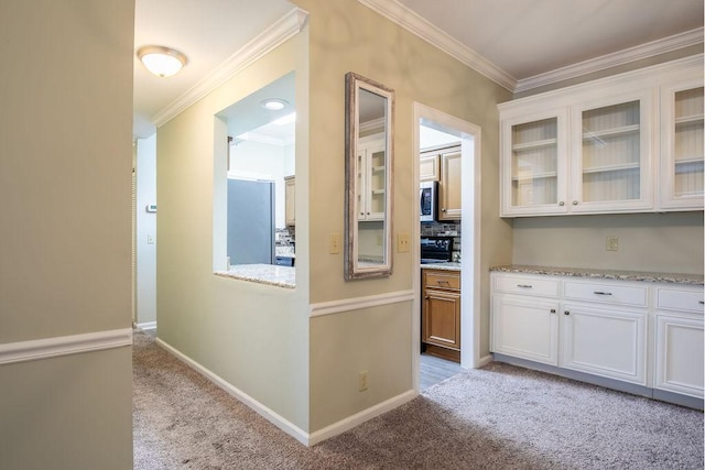 interior space with stainless steel appliances, glass insert cabinets, white cabinetry, and light colored carpet