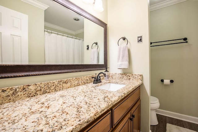 bathroom with toilet, wood finished floors, vanity, and crown molding