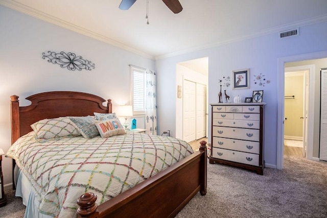 carpeted bedroom with a closet, visible vents, ornamental molding, ceiling fan, and baseboards