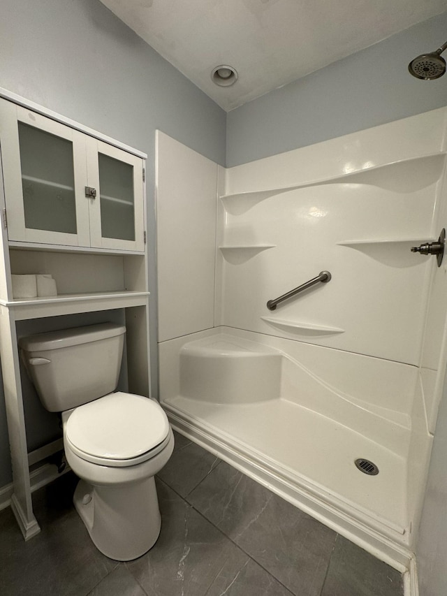 bathroom with a shower stall and toilet