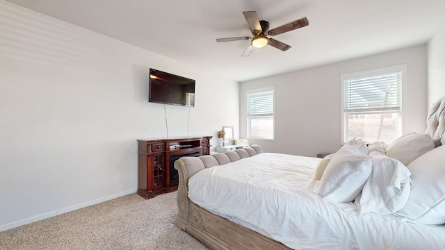 bedroom featuring light carpet, baseboards, and a ceiling fan