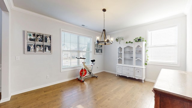 dining area featuring a notable chandelier, crown molding, and wood finished floors