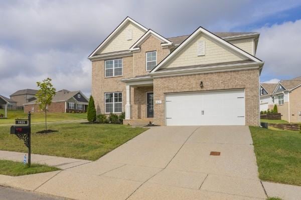 view of front facade with a garage, driveway, a front lawn, and brick siding