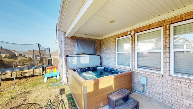 view of patio featuring a hot tub and a trampoline