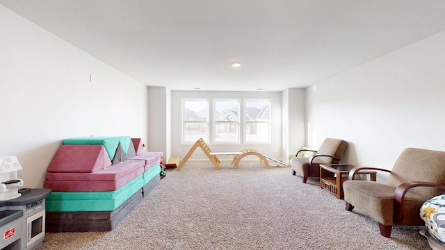 recreation room with carpet and baseboards