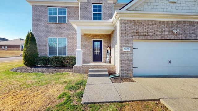 property entrance featuring driveway and brick siding