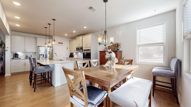 dining space with recessed lighting, visible vents, and light wood finished floors