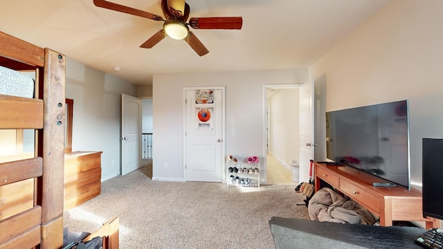 interior space featuring light carpet, baseboards, and a ceiling fan