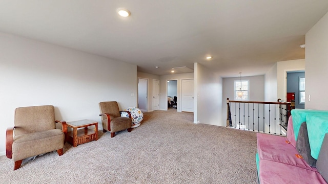 living area with recessed lighting, light colored carpet, and an upstairs landing