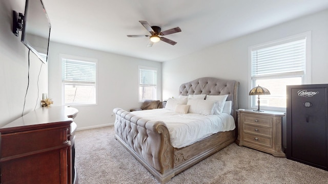 bedroom with light colored carpet, ceiling fan, and baseboards