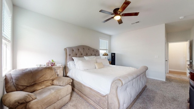 bedroom featuring light colored carpet, visible vents, ceiling fan, and baseboards