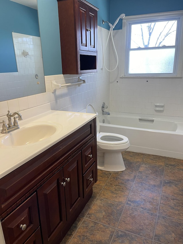 bathroom with toilet, vanity, tile walls, and bathing tub / shower combination
