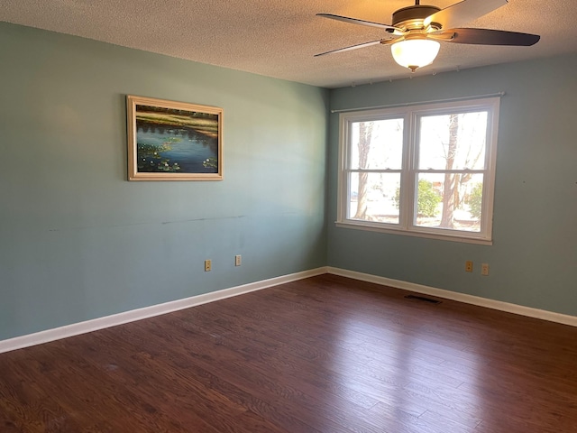 unfurnished room featuring dark wood-style floors, visible vents, ceiling fan, a textured ceiling, and baseboards