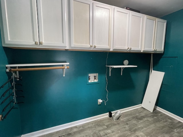 clothes washing area featuring cabinet space, baseboards, washer hookup, and wood finished floors