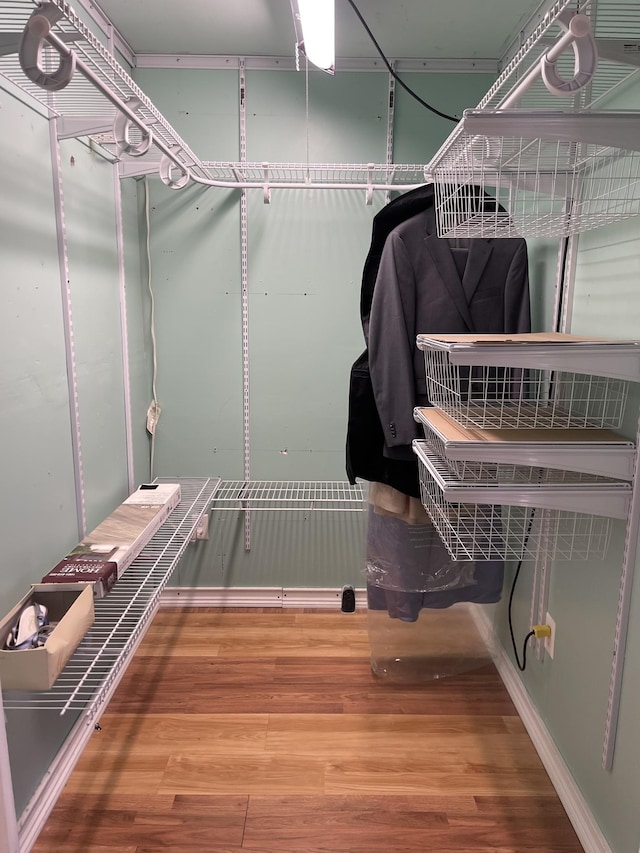 walk in closet with wood finished floors