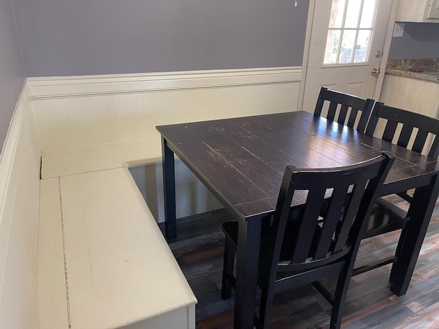 dining area featuring a wainscoted wall and wood finished floors