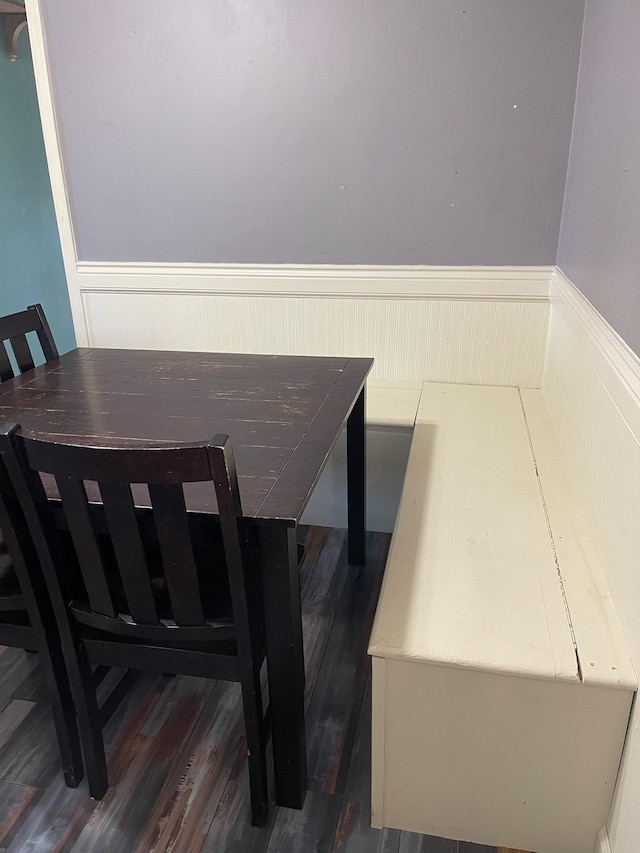 dining room with dark wood-style flooring and wainscoting