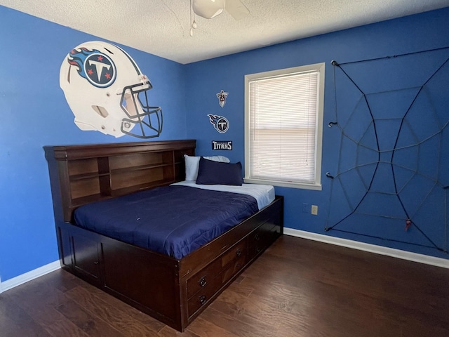 bedroom featuring dark wood-style floors, a ceiling fan, baseboards, and a textured ceiling