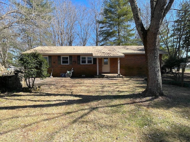 ranch-style home featuring a front yard, brick siding, and metal roof