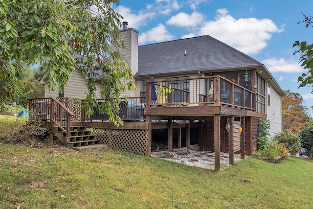 back of property featuring a deck, a yard, roof with shingles, and a sunroom