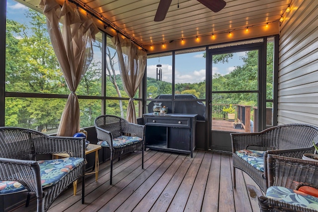 sunroom featuring wood ceiling, plenty of natural light, and a ceiling fan