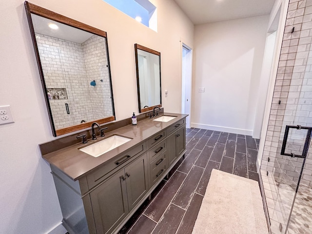 full bath with a stall shower, a sink, baseboards, and double vanity