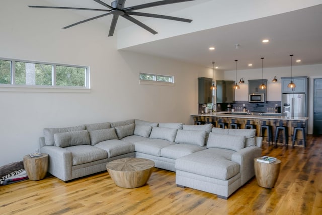 living area featuring recessed lighting, plenty of natural light, light wood-style flooring, and a ceiling fan