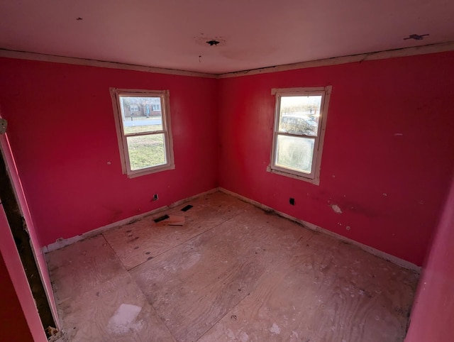 unfurnished room featuring a healthy amount of sunlight and baseboards