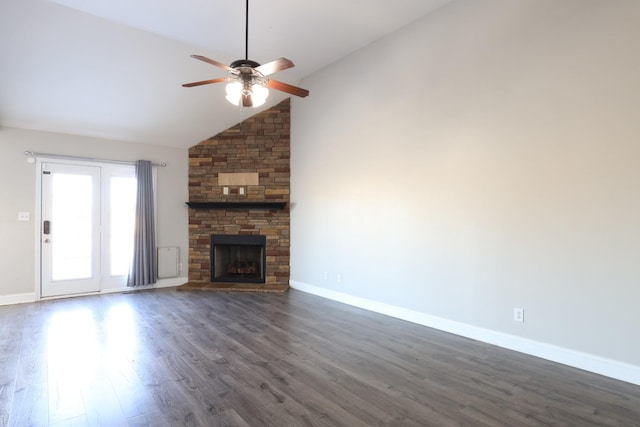 unfurnished living room with dark wood-style flooring, ceiling fan, a stone fireplace, high vaulted ceiling, and baseboards