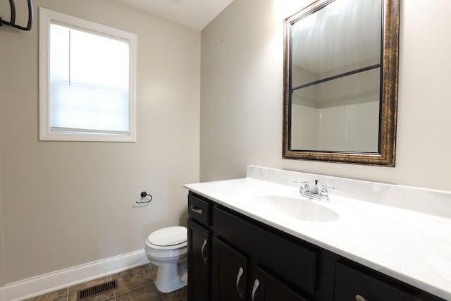 full bath featuring visible vents, toilet, vanity, baseboards, and walk in shower