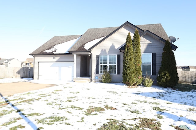 ranch-style home featuring a garage, a shingled roof, and fence