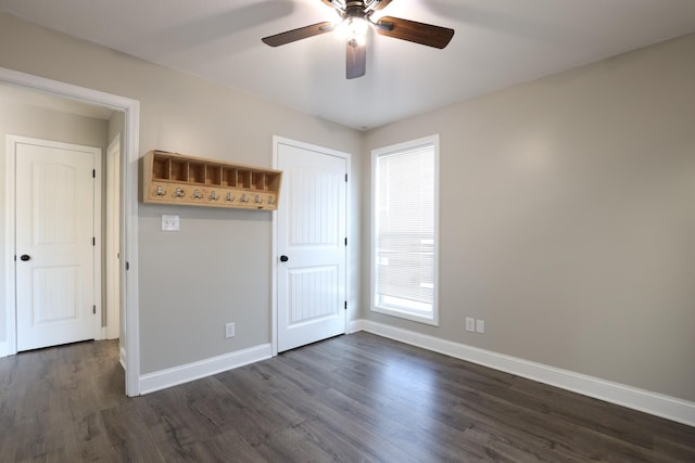 interior space featuring dark wood-style floors, ceiling fan, and baseboards