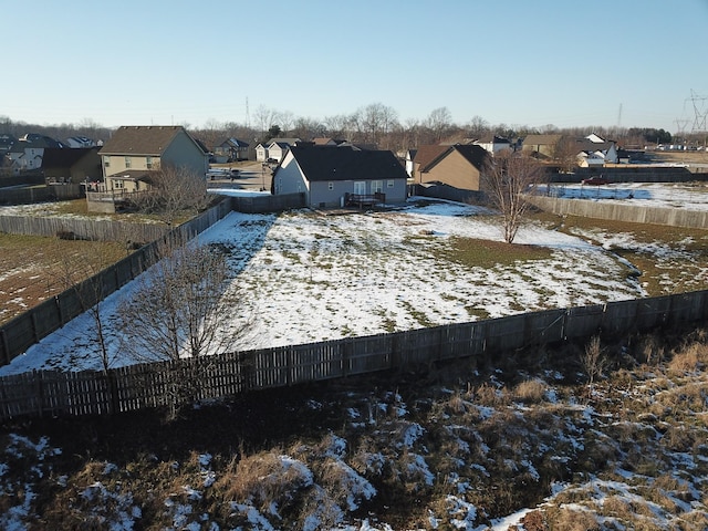 yard covered in snow featuring a residential view and fence