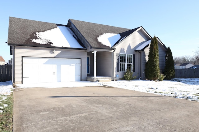 ranch-style house with an attached garage, a shingled roof, fence, and concrete driveway