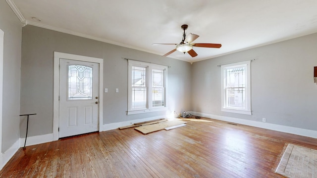 entryway with plenty of natural light, crown molding, wood-type flooring, and baseboards