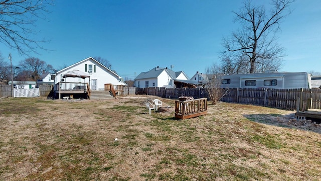 view of yard featuring a gate, a fenced backyard, a deck, and a gazebo