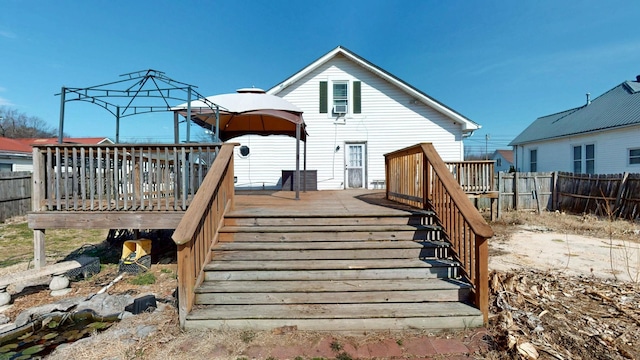 rear view of house featuring stairs, fence, and a wooden deck