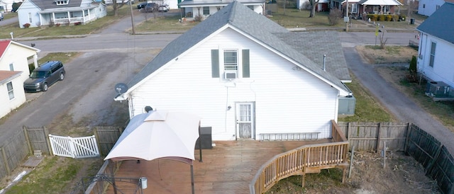 back of property with dirt driveway, a fenced backyard, and a residential view