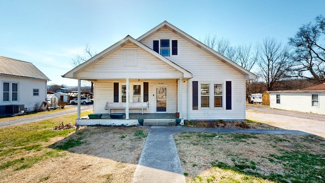 bungalow-style house featuring covered porch and central AC unit