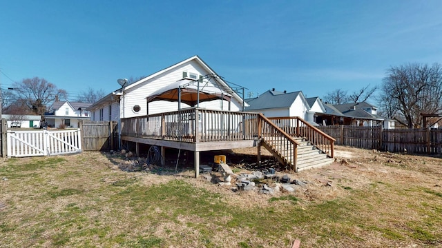 rear view of house with a wooden deck, a fenced backyard, a gazebo, a gate, and a yard