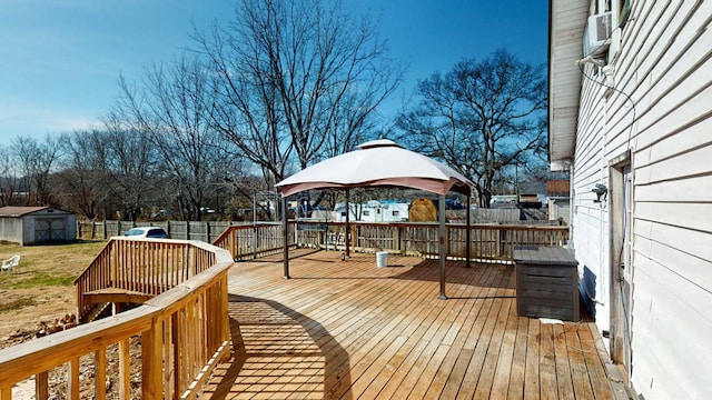 deck featuring an outbuilding, a storage unit, and a fenced backyard