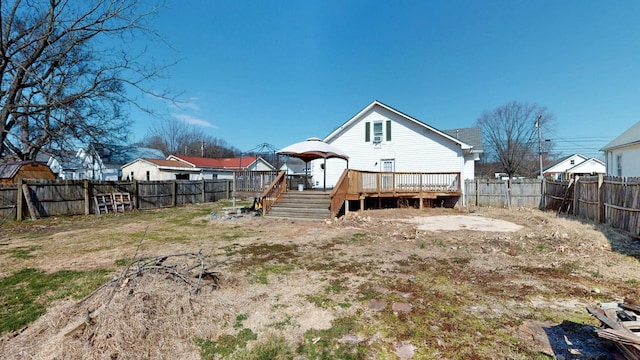 rear view of property with a fenced backyard and a wooden deck