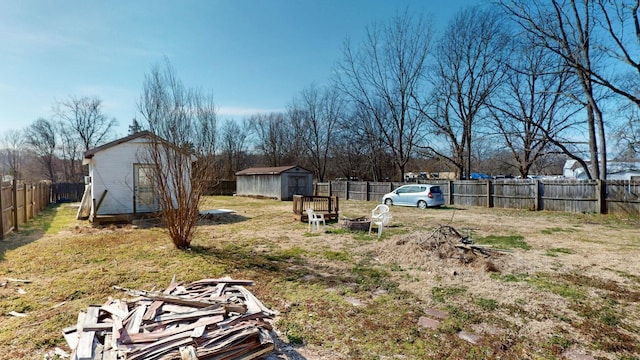 view of yard featuring a fenced backyard, an outdoor structure, and a shed