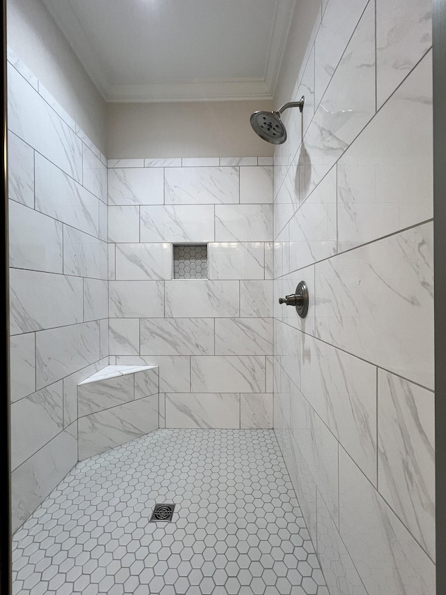 full bath with a tile shower and crown molding