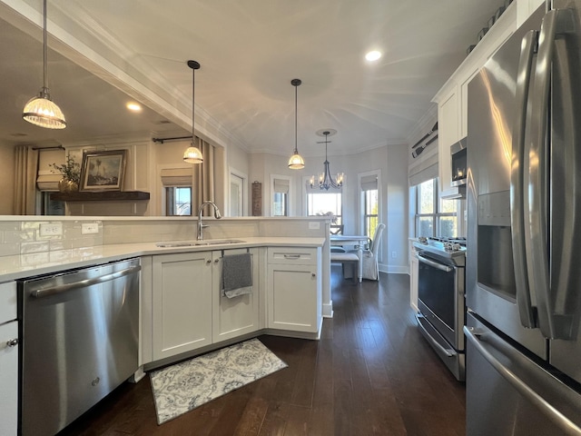 kitchen featuring stainless steel appliances, dark wood-style flooring, a sink, light countertops, and crown molding